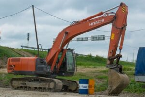 An excavator digging a trench, highlighting the process of utility trenching for infrastructure development.
